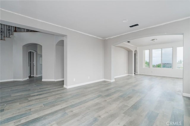 1059 Stowell Ranch Cir, Corona, CA 92881 - spare room featuring wood finished floors, visible vents, arched walkways, and baseboards