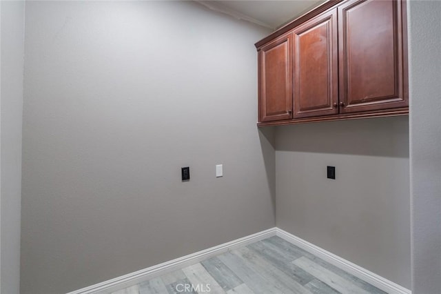 1059 Stowell Ranch Cir, Corona, CA 92881 - clothes washing area featuring light wood finished floors, electric dryer hookup, cabinet space, and baseboards