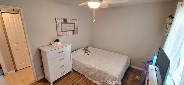 bedroom with light wood finished floors, a ceiling fan, and baseboards
