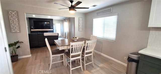 dining space with a healthy amount of sunlight, a ceiling fan, and light wood-style flooring