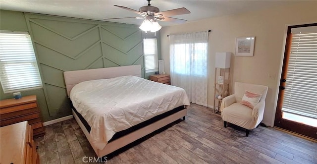 bedroom with ceiling fan, wood finished floors, and baseboards