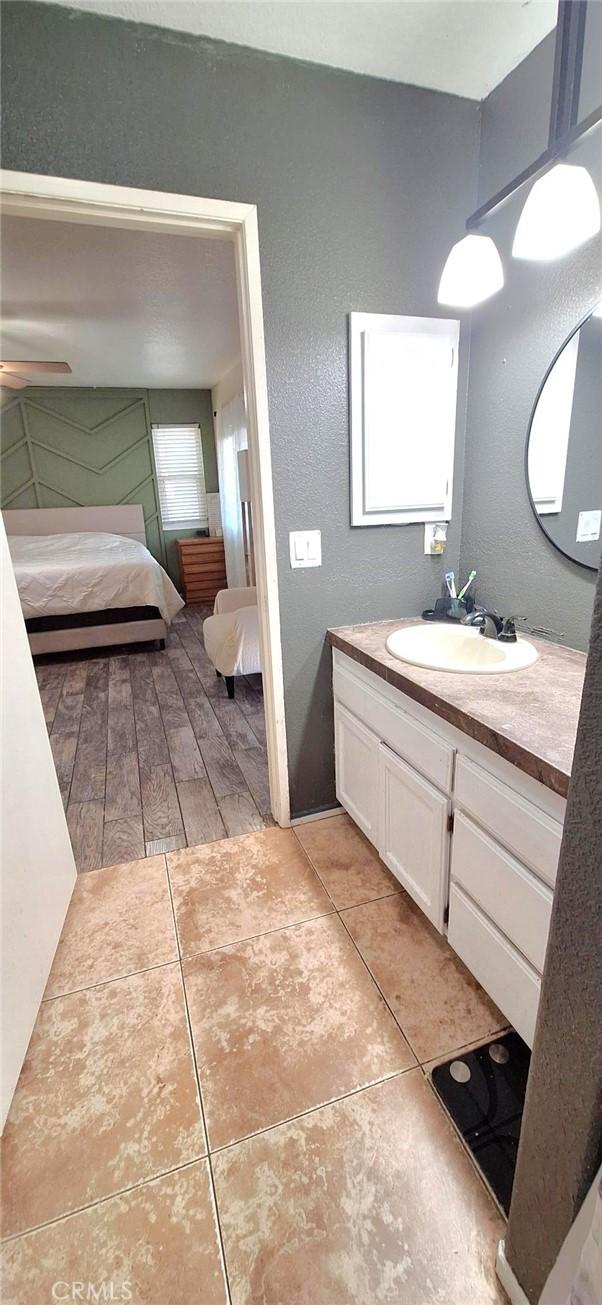 ensuite bathroom with vanity, ceiling fan, tile patterned floors, and ensuite bathroom