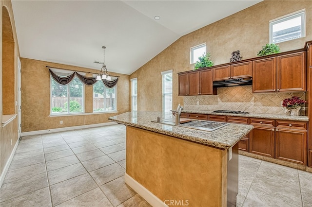 kitchen featuring vaulted ceiling, a healthy amount of sunlight, under cabinet range hood, and a sink