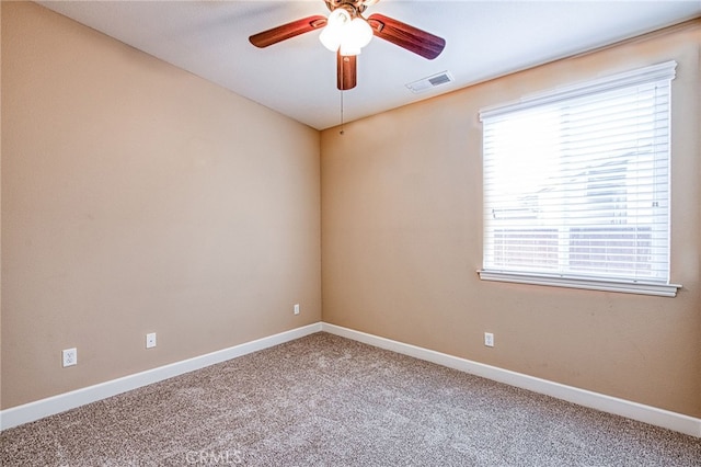 carpeted empty room with a wealth of natural light, visible vents, ceiling fan, and baseboards