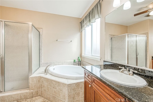 full bathroom with a garden tub, a stall shower, a ceiling fan, and vanity