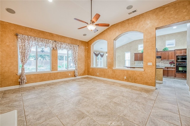 spare room with lofted ceiling, visible vents, ceiling fan, and plenty of natural light
