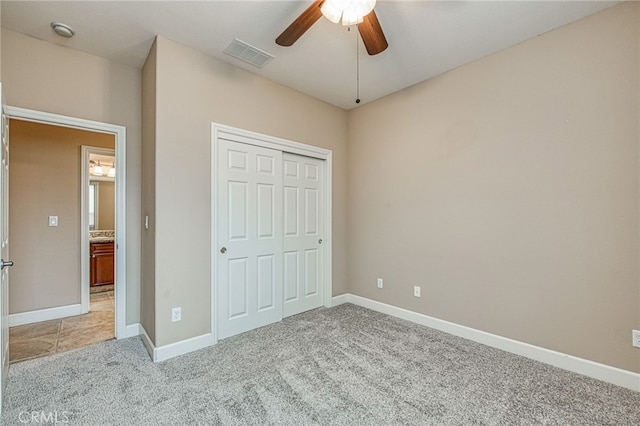 unfurnished bedroom featuring baseboards, visible vents, a closet, and light colored carpet
