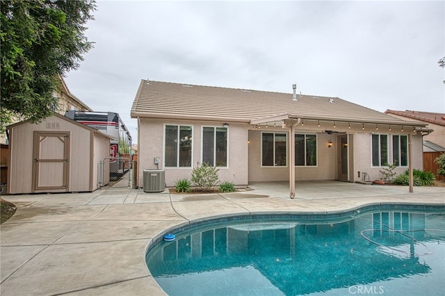 back of house featuring a tile roof, a patio, a gate, a storage shed, and fence