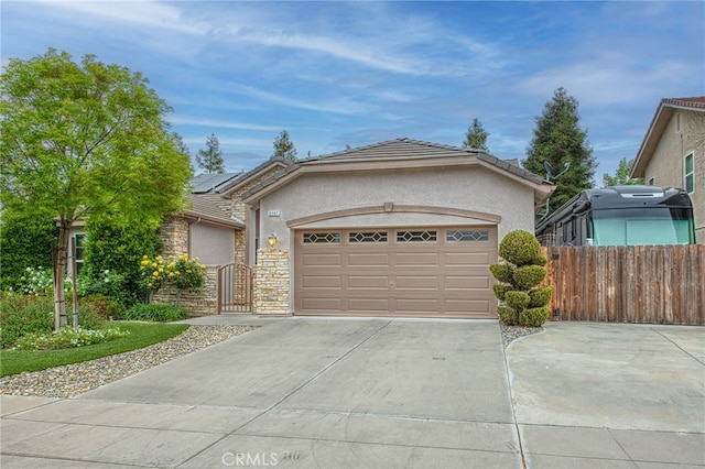 ranch-style home with roof mounted solar panels, driveway, stucco siding, and a gate