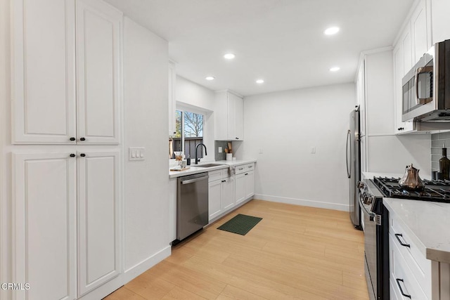 4490 Lubbock Dr Unit D, Simi Valley, CA 93063 - kitchen with white cabinets, stainless steel appliances, baseboards, and a sink