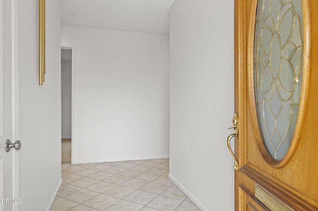 interior space with light tile patterned floors and baseboards