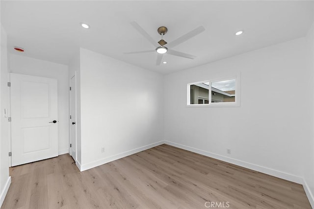 spare room with light wood finished floors, recessed lighting, ceiling fan, and baseboards