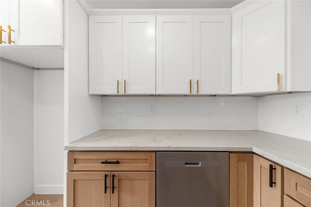 kitchen featuring white cabinetry, light stone countertops, stainless steel dishwasher, and backsplash