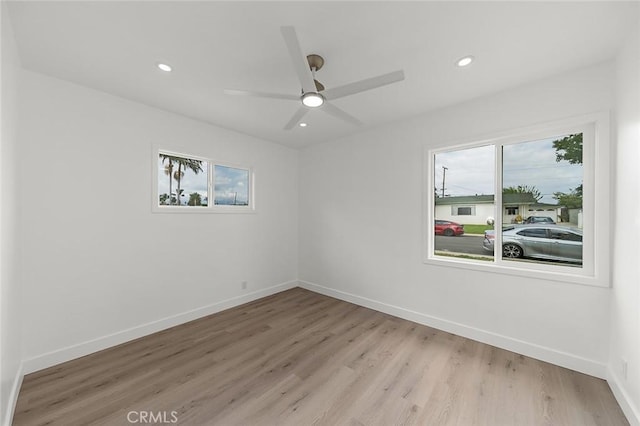empty room featuring light wood-type flooring, a healthy amount of sunlight, and recessed lighting