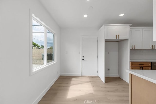 kitchen featuring baseboards, recessed lighting, light countertops, and light wood-style flooring