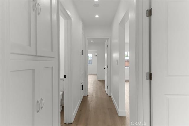 hallway with wood finished floors, recessed lighting, and baseboards