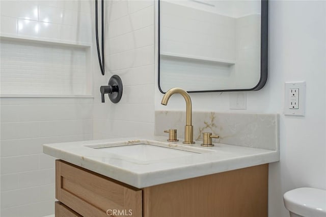 bathroom featuring toilet, vanity, and tasteful backsplash