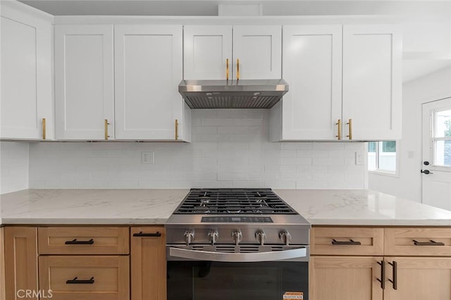 kitchen featuring tasteful backsplash, light stone countertops, gas range, and under cabinet range hood