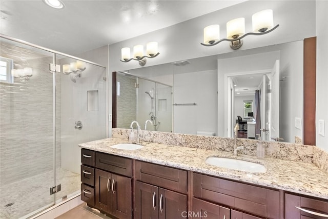 full bath with double vanity, a sink, and a shower stall