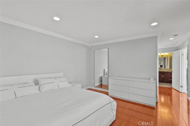 bedroom with wood finished floors, recessed lighting, ornamental molding, and baseboards
