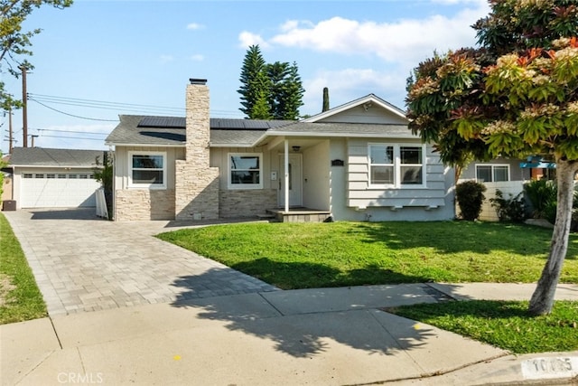 view of front facade with a chimney, stone siding, roof mounted solar panels, and a front yard