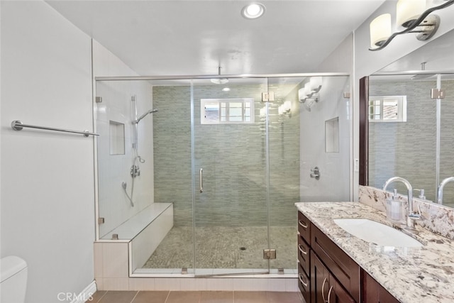 full bath with a stall shower, a healthy amount of sunlight, toilet, and vanity
