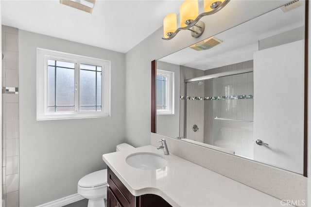 bathroom with visible vents, tiled shower, toilet, and vanity