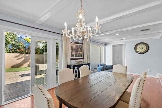 dining room with a notable chandelier, visible vents, and beam ceiling