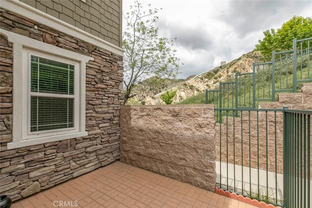 view of patio featuring fence and a mountain view