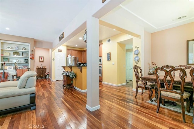 living room featuring baseboards, visible vents, and light wood-style floors
