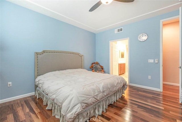 bedroom featuring baseboards, visible vents, wood finished floors, and ensuite bath