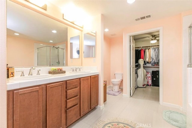 full bathroom featuring visible vents, a sink, double vanity, and a shower stall