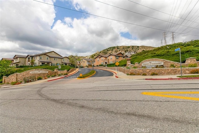 view of street with curbs, traffic signs, sidewalks, and a residential view