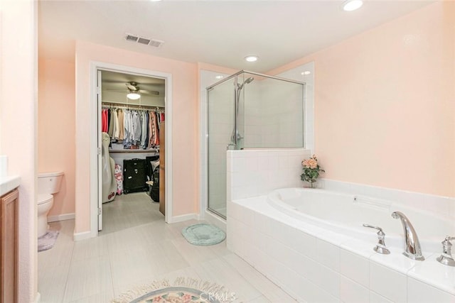 bathroom featuring a shower stall, toilet, a garden tub, and a spacious closet