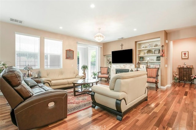 living room with visible vents, recessed lighting, light wood finished floors, and a fireplace