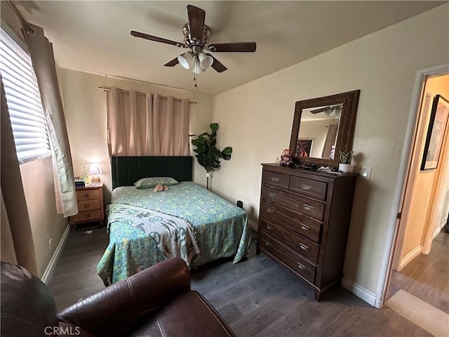 bedroom with baseboards, ceiling fan, and dark wood-type flooring