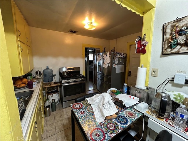 kitchen featuring light tile patterned floors, appliances with stainless steel finishes, and visible vents