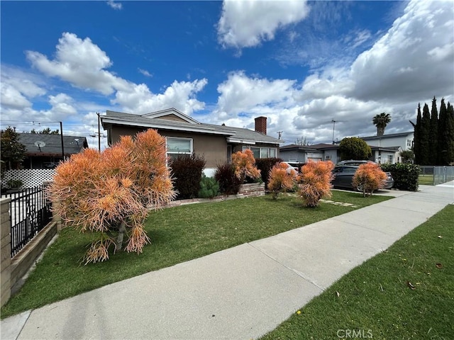 single story home featuring fence and a front lawn