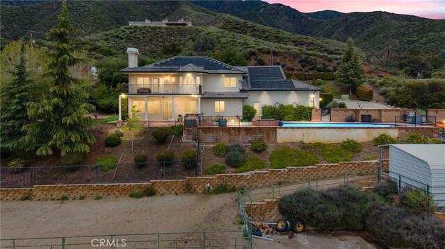 280 W 26th St, Upland, CA 91784 - back of house featuring a balcony, a fenced backyard, and a chimney