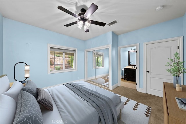 bedroom featuring carpet floors, baseboards, a ceiling fan, a closet, and connected bathroom