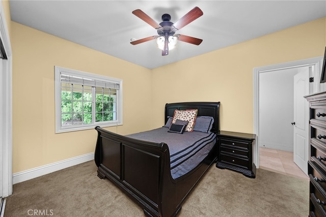 bedroom with light colored carpet, baseboards, and a ceiling fan
