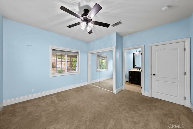 unfurnished bedroom featuring carpet flooring, baseboards, a closet, and a ceiling fan