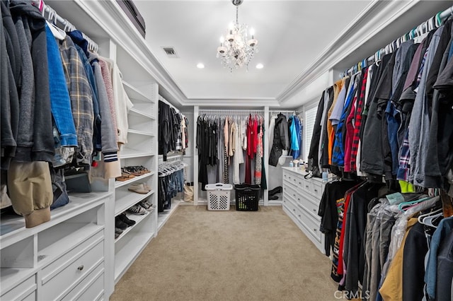 spacious closet with a chandelier and light colored carpet