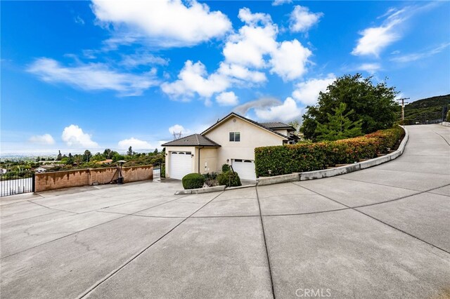 280 W 26th St, Upland, CA 91784 - view of side of property with a garage, concrete driveway, fence, and stucco siding