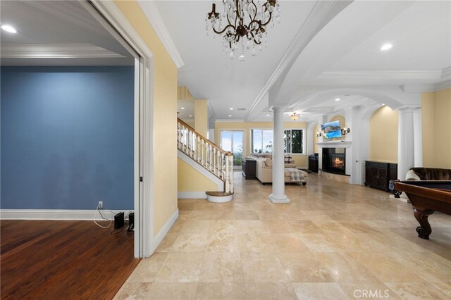280 W 26th St, Upland, CA 91784 - foyer entrance with decorative columns, a lit fireplace, baseboards, crown molding, and stairs