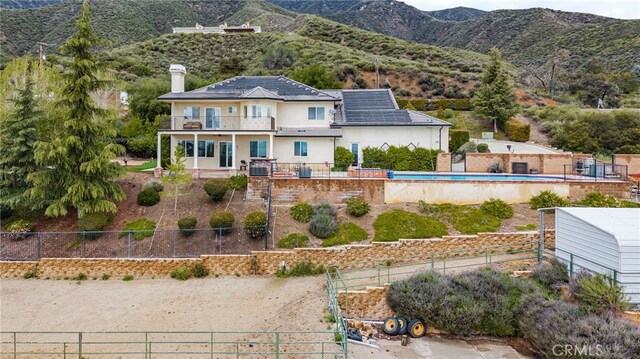 280 W 26th St, Upland, CA 91784 - rear view of property with a fenced backyard, a balcony, a chimney, a mountain view, and stucco siding