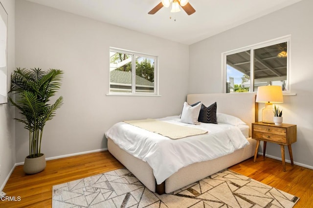 bedroom featuring a ceiling fan, wood finished floors, and baseboards