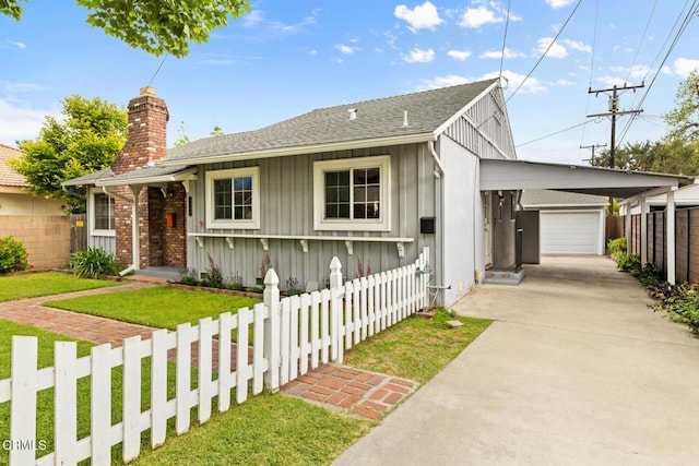 ranch-style house with driveway, board and batten siding, a shingled roof, a front yard, and fence private yard