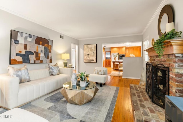 living room with a fireplace, ornamental molding, wood finished floors, and visible vents