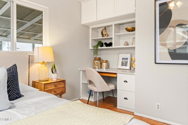 bedroom with light wood finished floors and baseboards